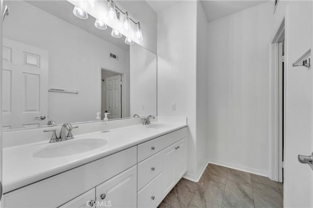 full bath with double vanity, a sink, visible vents, and baseboards