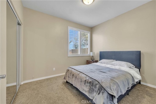 carpeted bedroom featuring a closet and baseboards