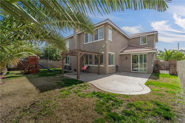 back of property featuring a patio, a lawn, a playground, and stucco siding