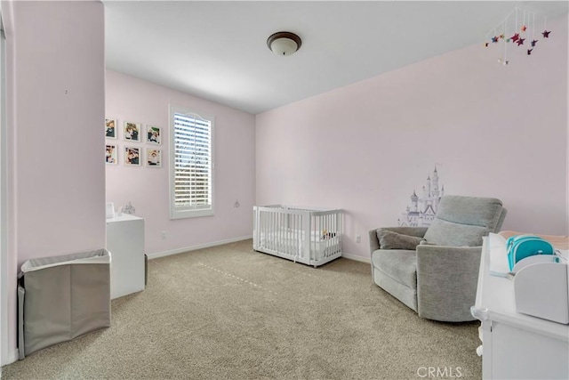 carpeted bedroom with a crib and baseboards