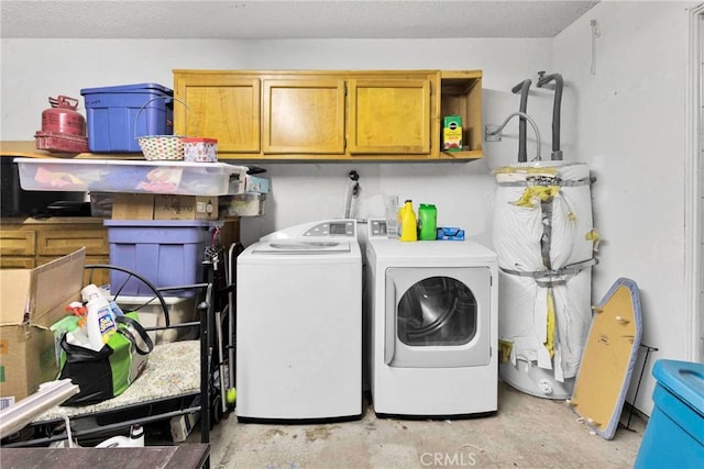 laundry room with cabinet space, washing machine and clothes dryer, and secured water heater