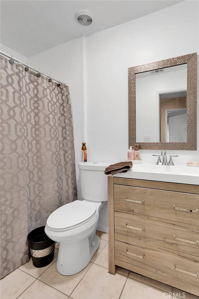 bathroom featuring toilet, vanity, visible vents, and tile patterned floors