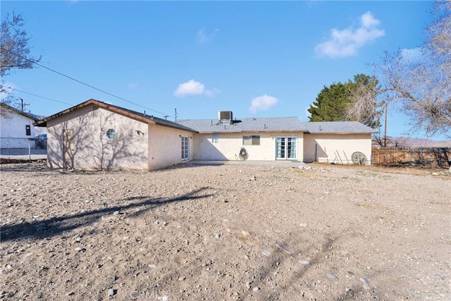 back of house featuring fence and stucco siding