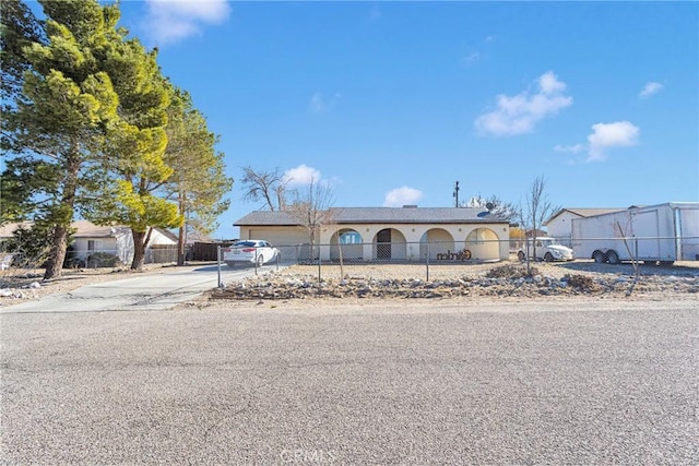 view of front of home with a garage, concrete driveway, and fence