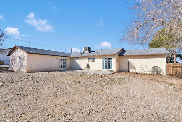 back of property with central air condition unit, a patio area, fence, and stucco siding