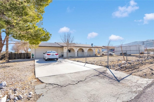 single story home with driveway, an attached garage, and fence