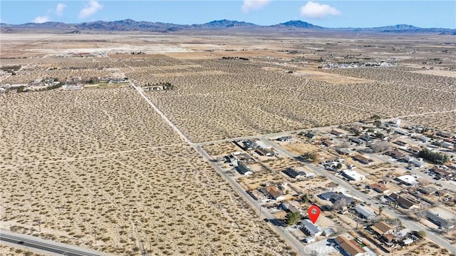 drone / aerial view featuring a desert view and a mountain view