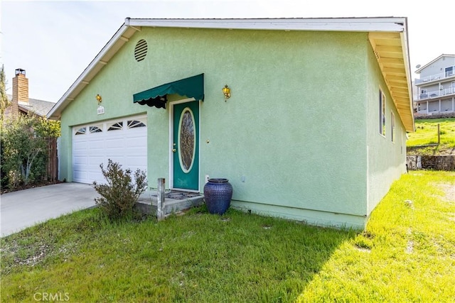 view of front of house with stucco siding, an attached garage, concrete driveway, and a front yard