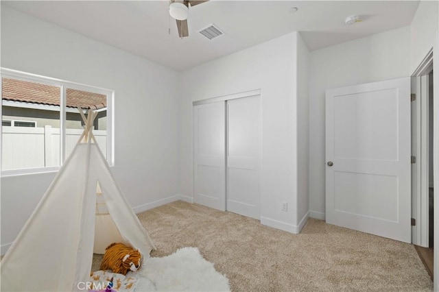 bedroom with light colored carpet, a closet, visible vents, and baseboards