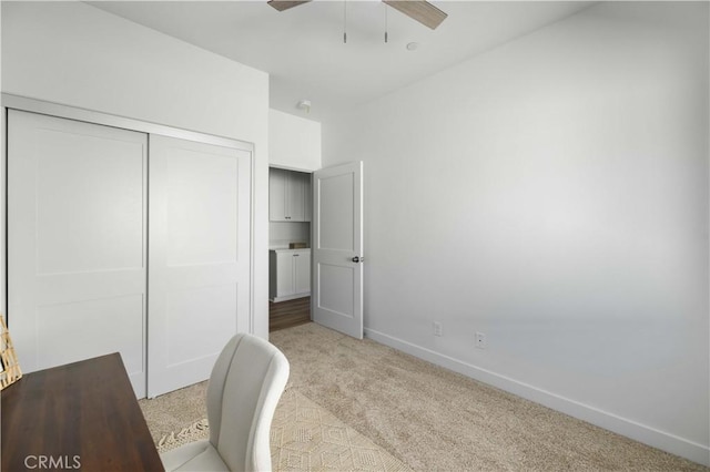 office with baseboards, ceiling fan, and light colored carpet