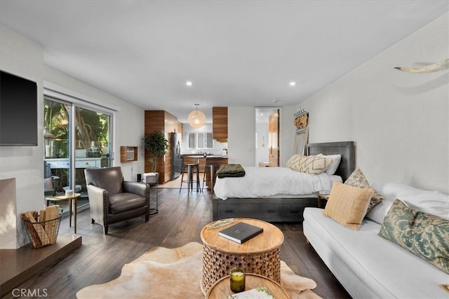 bedroom with hardwood / wood-style flooring, recessed lighting, and freestanding refrigerator