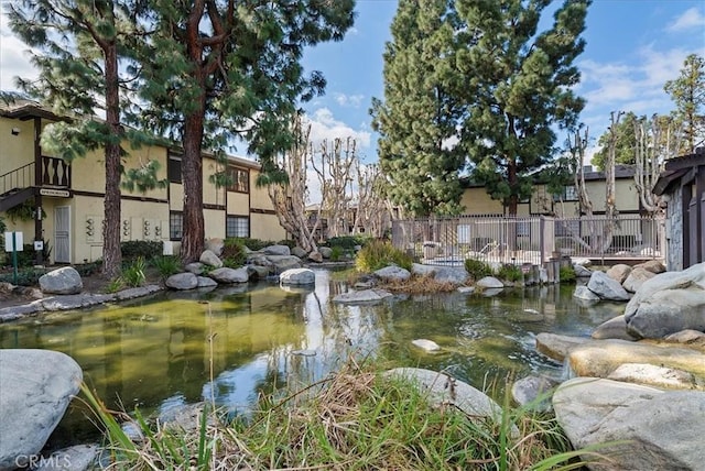 view of property's community with a small pond