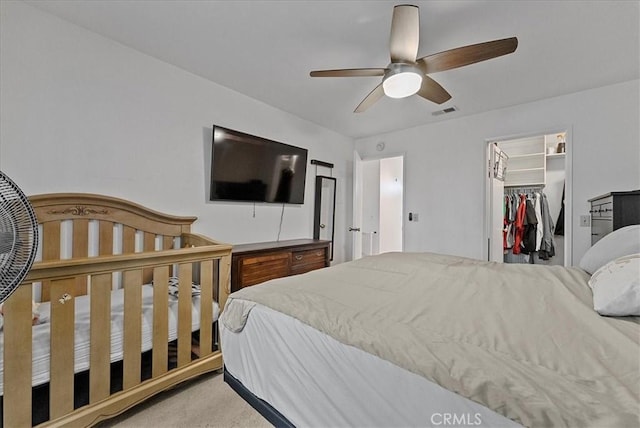 bedroom featuring visible vents, a ceiling fan, a spacious closet, a closet, and carpet