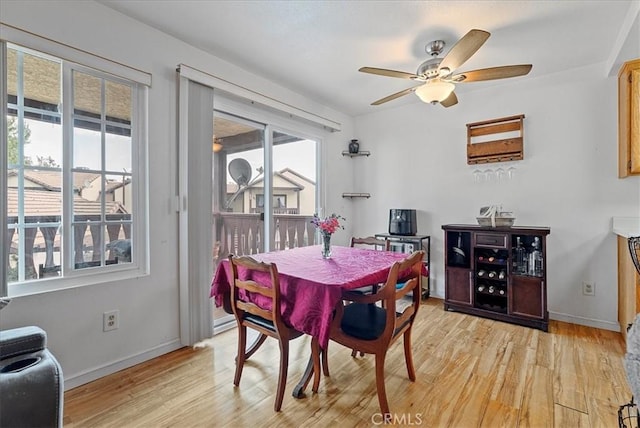 dining room with light wood-style floors, baseboards, and a ceiling fan