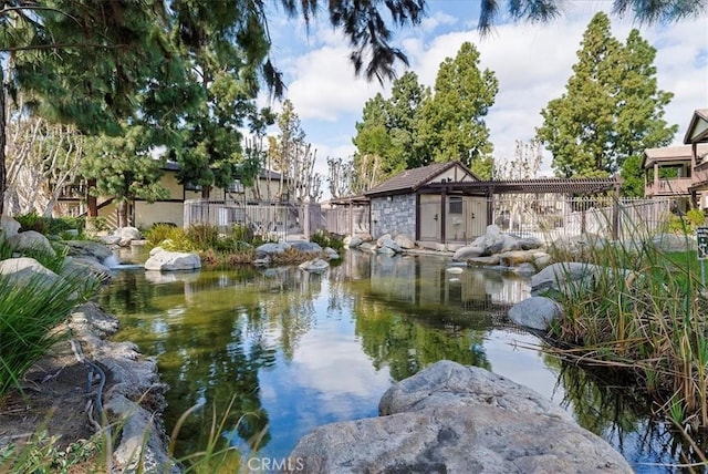 view of water feature featuring a small pond and fence