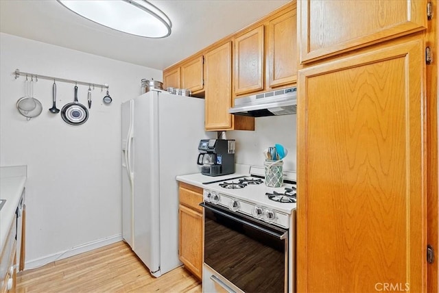 kitchen featuring under cabinet range hood, white appliances, baseboards, light countertops, and light wood finished floors