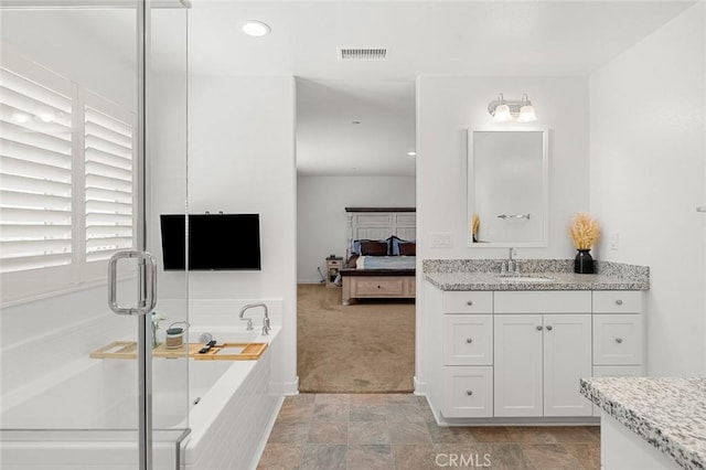 ensuite bathroom featuring a garden tub, connected bathroom, vanity, visible vents, and a stall shower