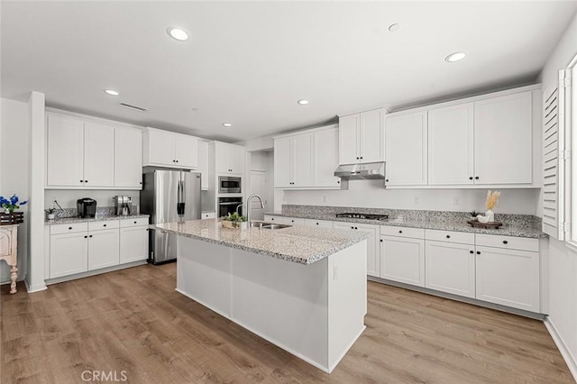 kitchen featuring stainless steel appliances, white cabinetry, a sink, and under cabinet range hood