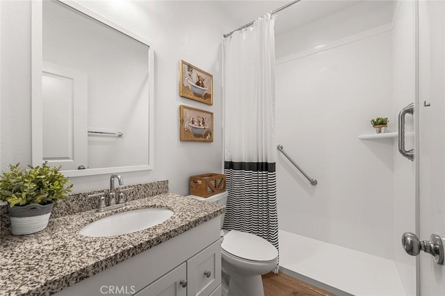 bathroom featuring a shower with shower curtain, vanity, toilet, and wood finished floors