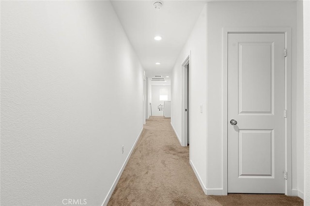 hall with recessed lighting, light colored carpet, and baseboards