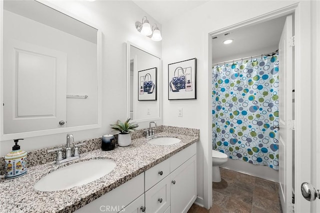 bathroom featuring shower / bath combination with curtain, a sink, toilet, and double vanity