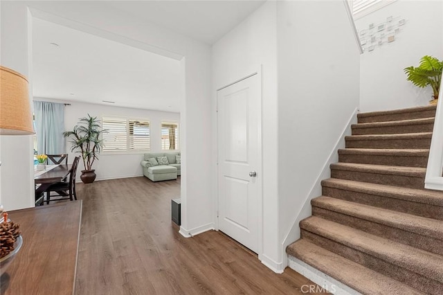 stairway with wood finished floors and baseboards