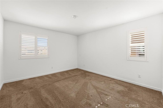 carpeted spare room with baseboards