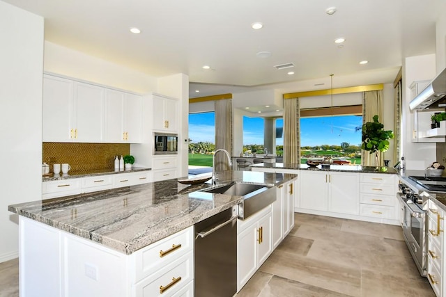 75851 Via Pisa, Indian Wells, CA 92210 - kitchen featuring a kitchen island with sink, stainless steel appliances, a sink, white cabinets, and dark stone counters