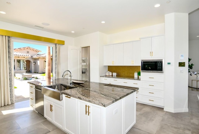 75851 Via Pisa, Indian Wells, CA 92210 - kitchen featuring black microwave, a sink, white cabinetry, dark stone countertops, and a center island with sink