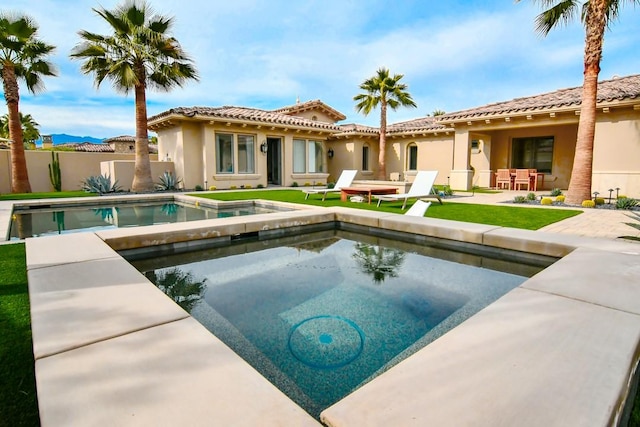 75851 Via Pisa, Indian Wells, CA 92210 - rear view of house with a fenced in pool, a patio, an in ground hot tub, fence, and stucco siding