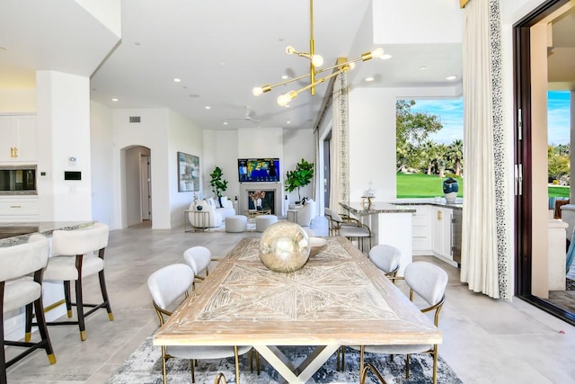 75851 Via Pisa, Indian Wells, CA 92210 - dining room with visible vents, arched walkways, an inviting chandelier, a fireplace, and recessed lighting