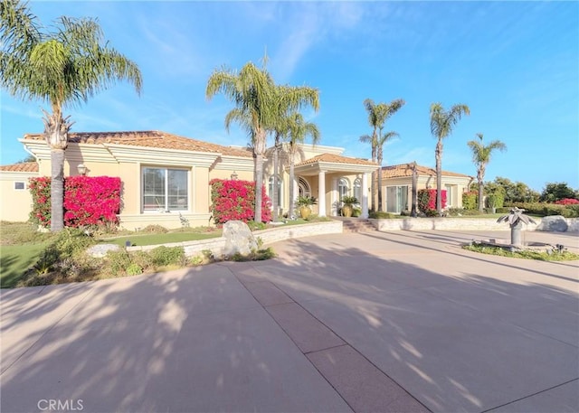 mediterranean / spanish-style house featuring a tiled roof and stucco siding