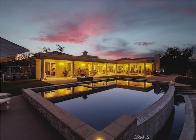 view of pool featuring a pool with connected hot tub and a patio area