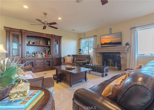 living room featuring a glass covered fireplace, a ceiling fan, and recessed lighting