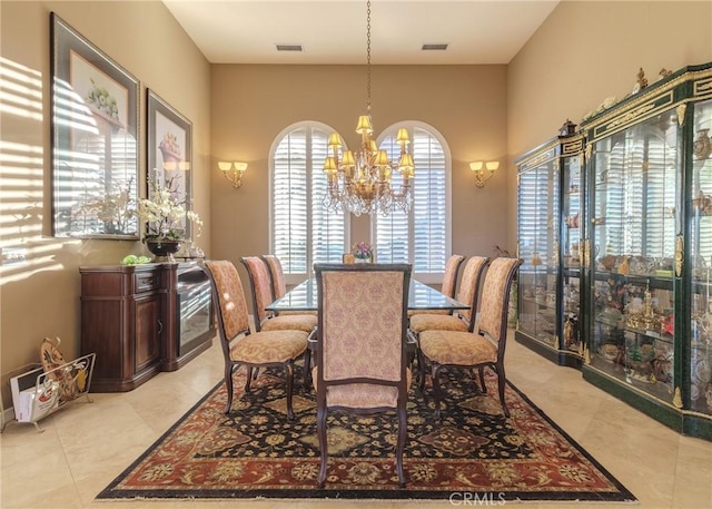 dining space with light tile patterned floors, visible vents, and a notable chandelier