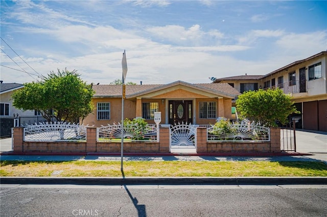 view of front of home featuring a fenced front yard, a gate, and stucco siding