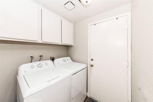 laundry area featuring independent washer and dryer, visible vents, and cabinet space