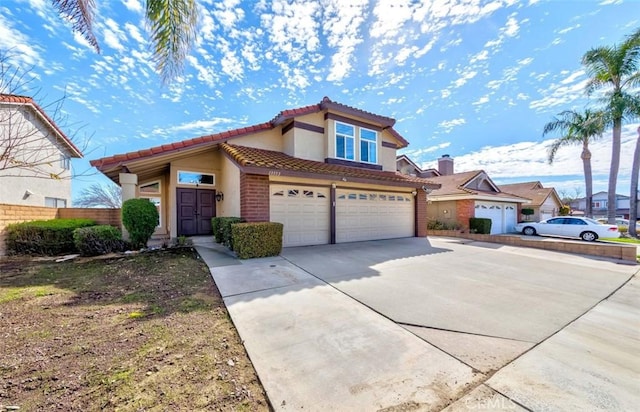 view of front of home with concrete driveway, a tile roof, fence, and stucco siding