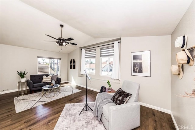 interior space with lofted ceiling, dark wood finished floors, baseboards, and ceiling fan