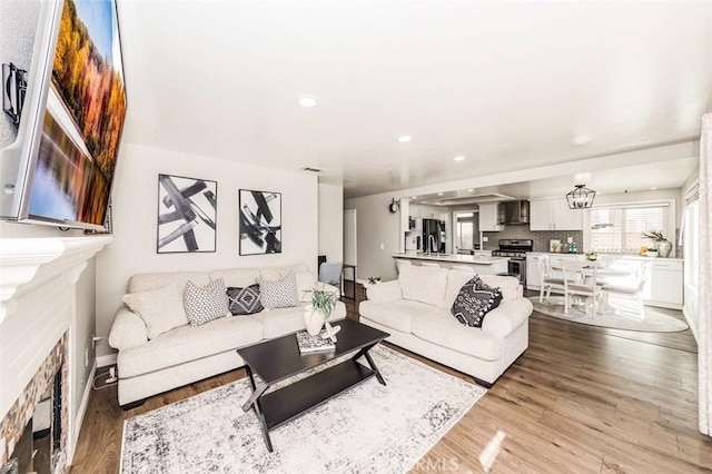 living area featuring a fireplace, wood finished floors, and recessed lighting