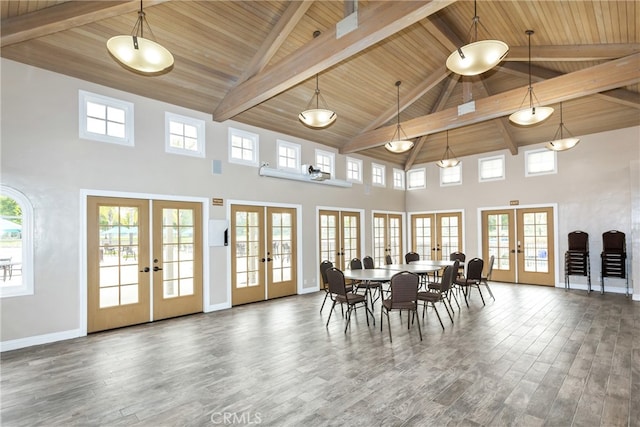 dining room with baseboards, lofted ceiling with beams, wooden ceiling, wood finished floors, and french doors