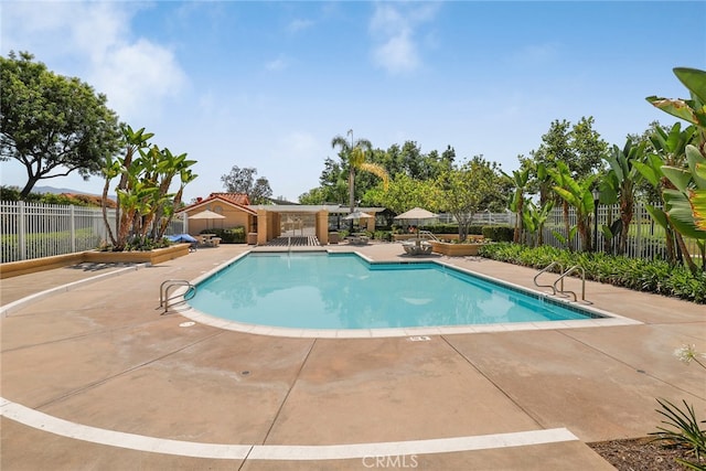 pool with a patio area and fence