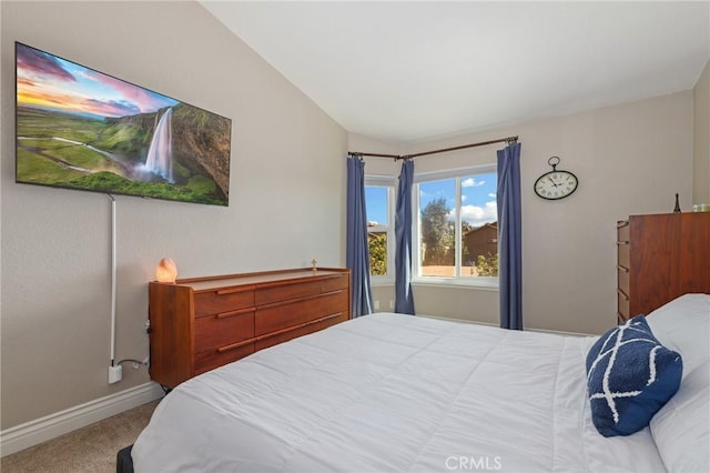 carpeted bedroom featuring vaulted ceiling and baseboards