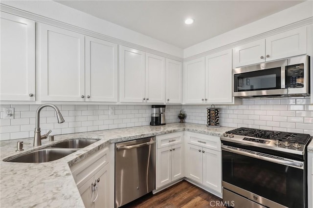 kitchen with appliances with stainless steel finishes, white cabinets, and a sink