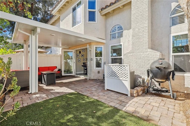 view of patio featuring grilling area, fence, and an outdoor living space