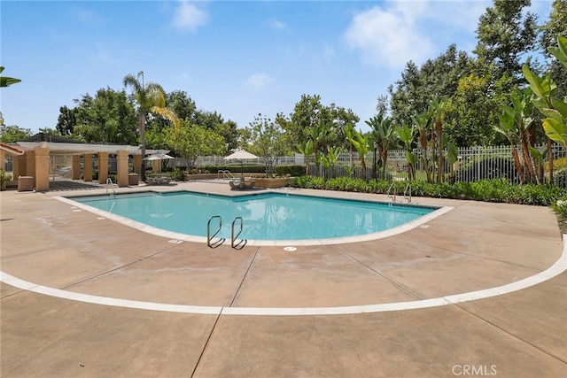 pool featuring fence and a patio