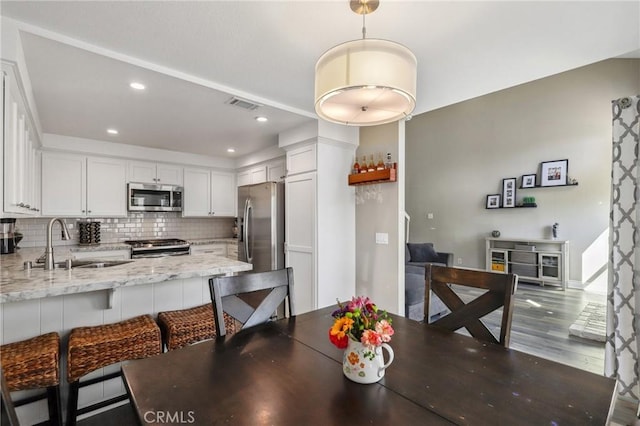 dining area with baseboards, dark wood finished floors, visible vents, and recessed lighting