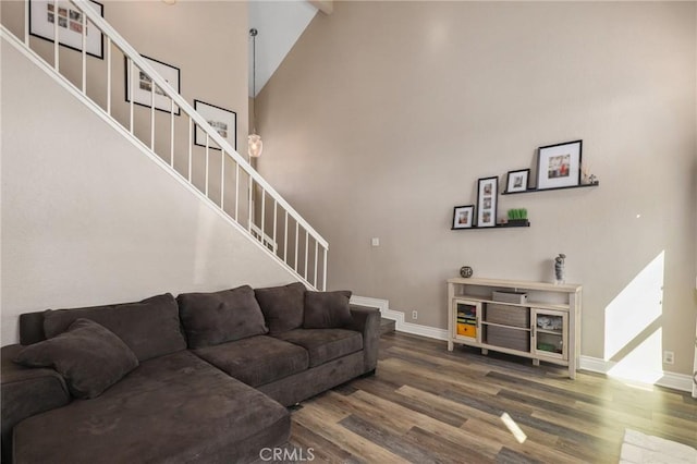 living room with a high ceiling, stairway, wood finished floors, and baseboards