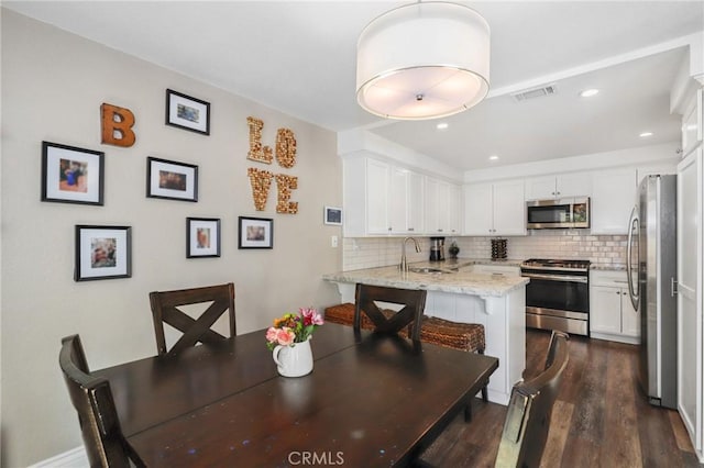 dining area with dark wood-style floors, visible vents, and recessed lighting