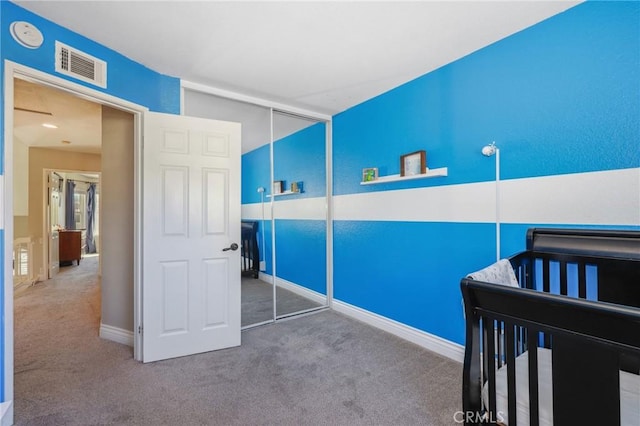 bedroom featuring a closet, carpet, visible vents, and baseboards